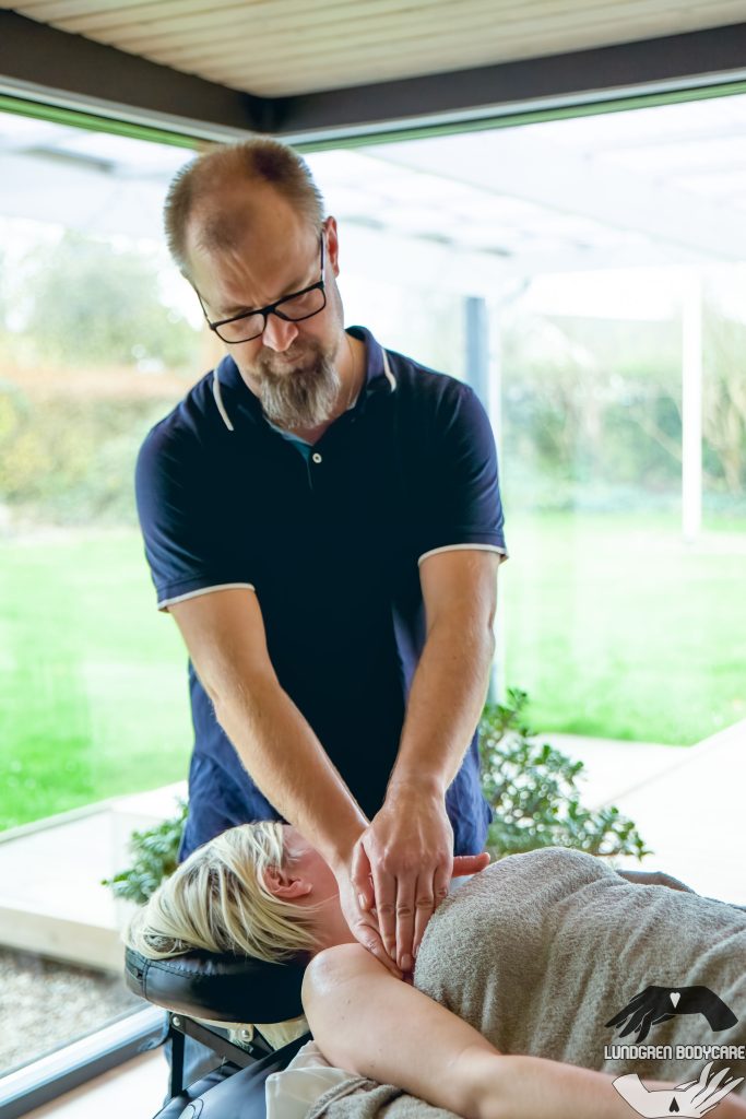 Her står vores Massør og giver massage af den øvre brystkasse